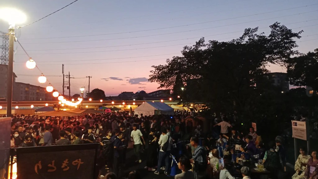 A local summer festival in Machida. It's night. Atmospheric lighting. Lots of people.