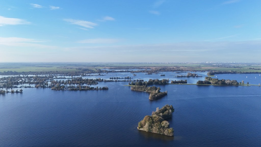 Drone footage of the area of the Vinkeveense Plassen. Blue sky, blue water, small islands.