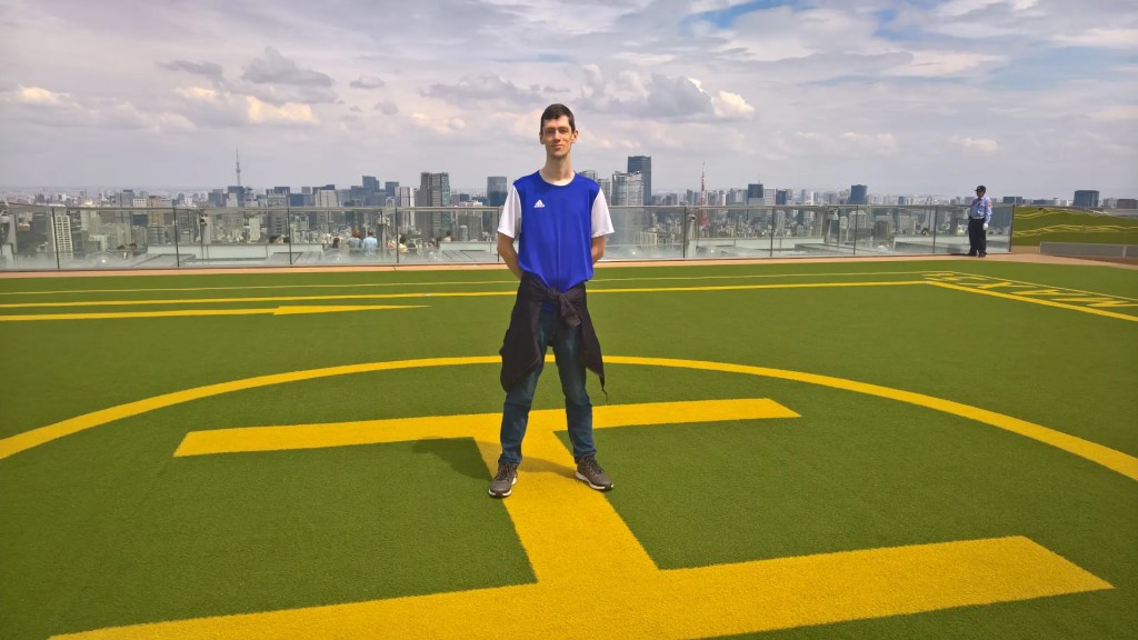 Self-portrait on top of a helipad with the Tokyo skyline in the background.